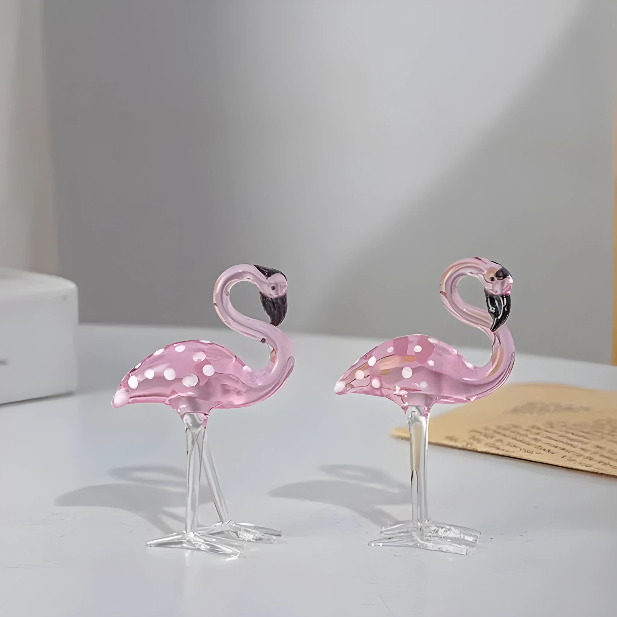 Pink flamingo decorative ornament made of white crystal on a table.
