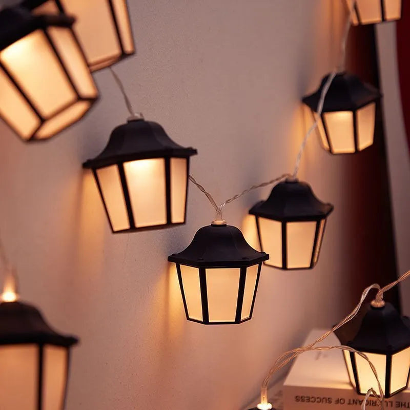 Solar LED lighting chain with warm white retro lamps on a garden fence at dusk