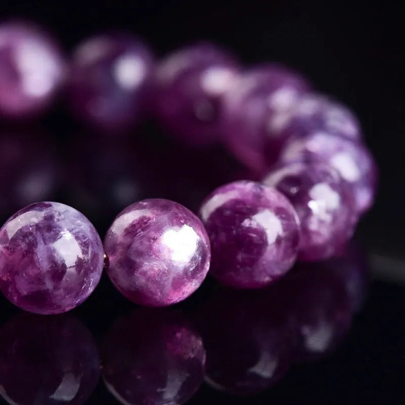 Grandmother crystal bracelet with polished purple geometry beads on a white background.