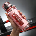 Blue portable sport water bottle with black lid on a gym bag.