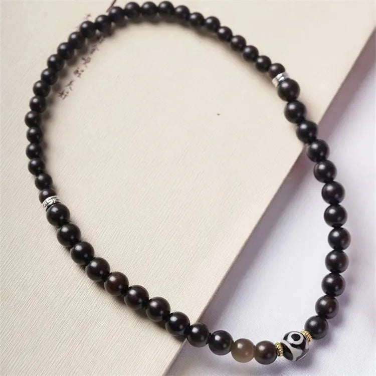 Close-up of Tibetan-style ebony wood bead bracelet showing 8mm diameter beads in two-circle layered design