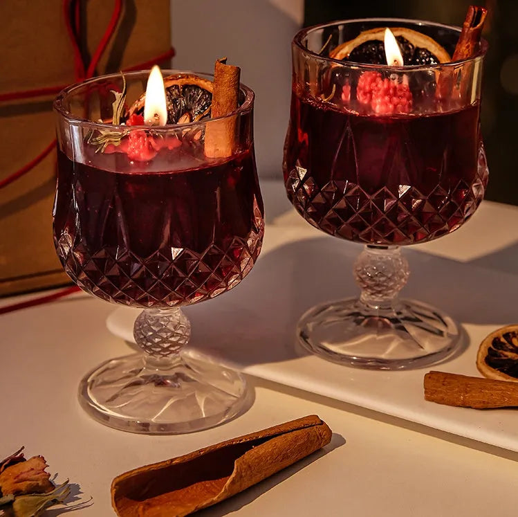 Glass wine goblet shaped container holding a French mulled wine scented aromatherapy candle.