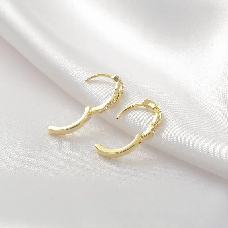 Gold geometric interwoven hemp rope earclip earrings on a white background