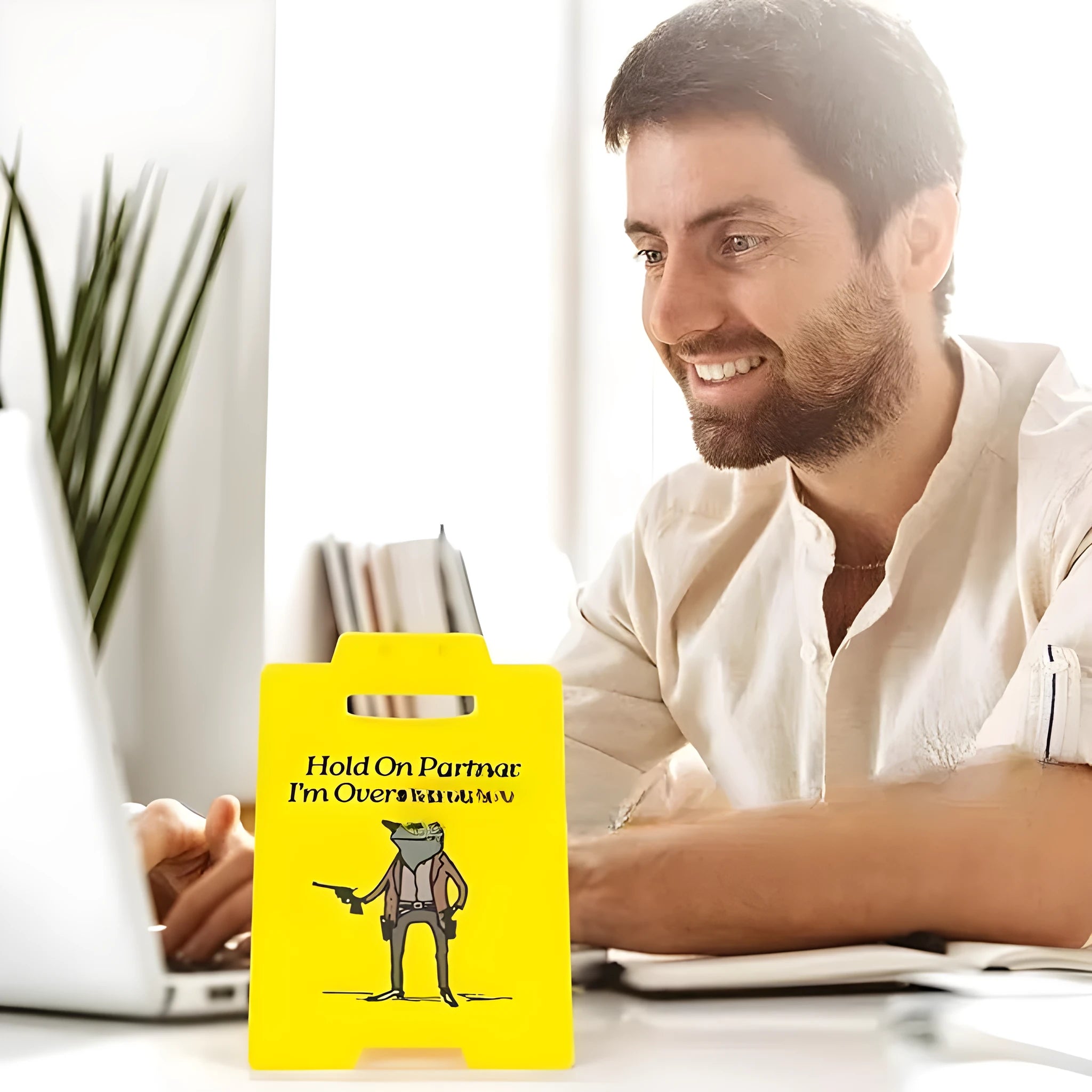 Yellow plastic humour desk ornament with 'I Am So Excited' text on a simple modern background