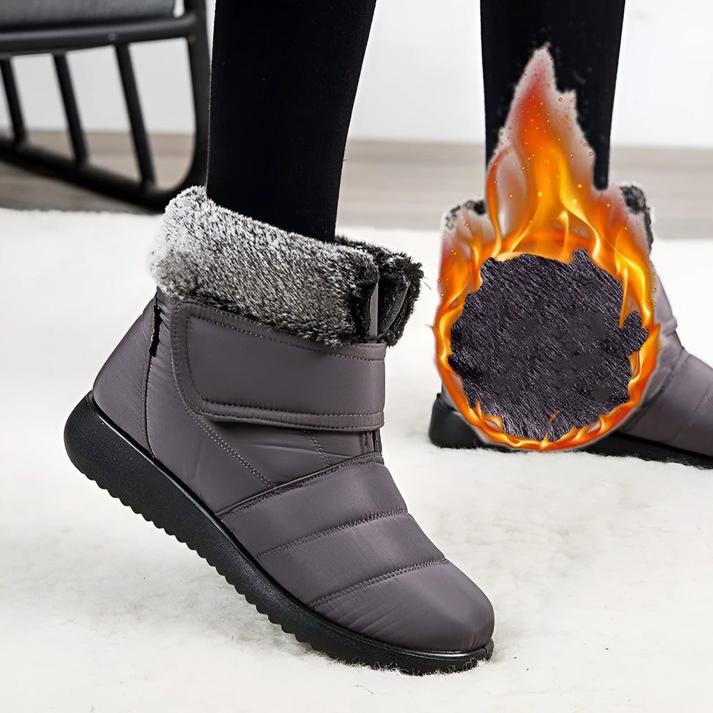 Women's winter snow boots with plush lining, suede upper, velcro strap, flat heel, and anti-skid rubber sole in black.