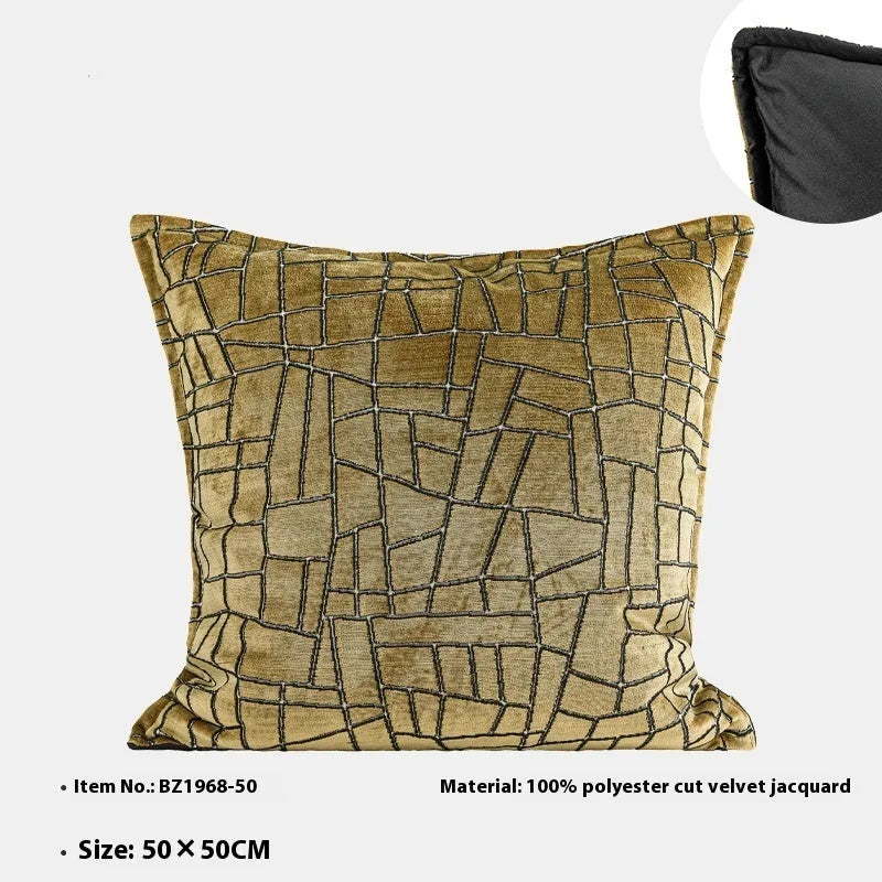 Geometric patterned cushion covers in gold colour on a grey sofa.