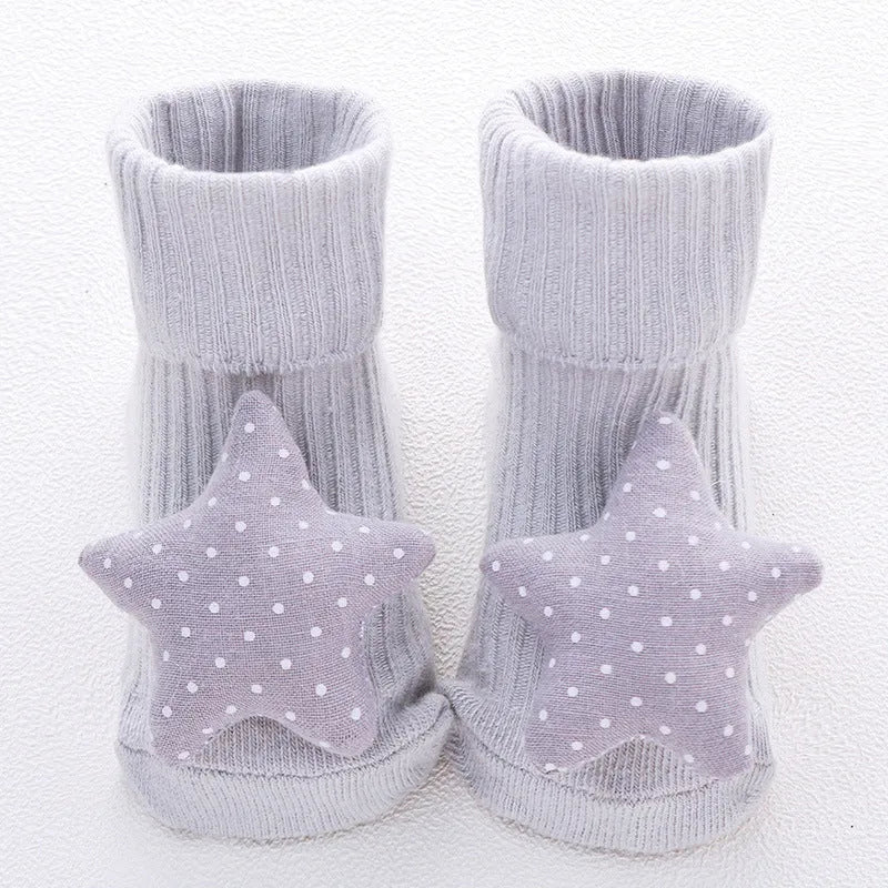 Cotton baby floor socks in assorted colours and prints like blue bow and pink stars on a size chart.