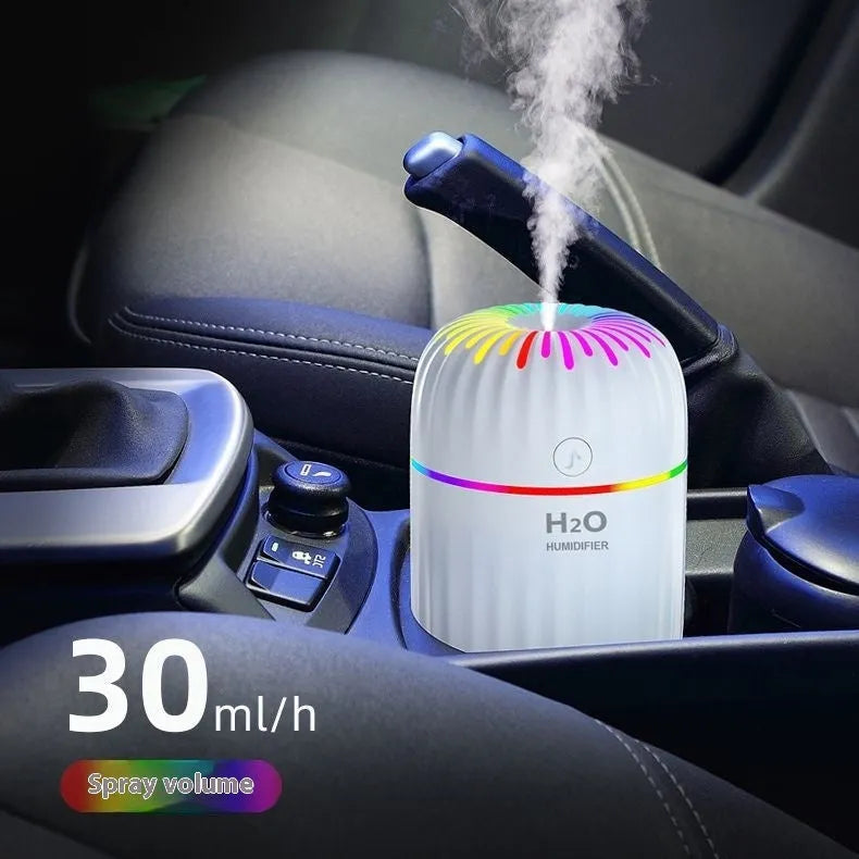 Green mini car USB aromatherapy humidifier on a desk with USB cable.