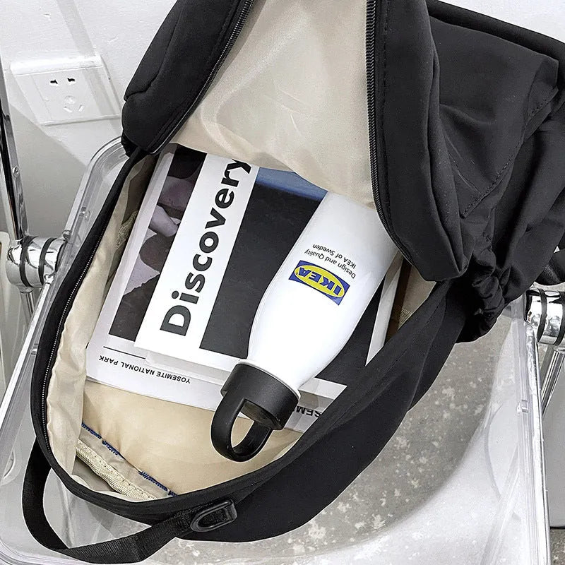 Nylon backpack school bag for junior high students, large capacity 20-35L, waterproof, with computer pocket, available in black.