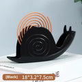 Black plastic universal mosquito incense holder on a table, simple portable design with creative animal style