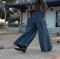 Grey men's wide-leg trousers with pleated waist detailing and elasticated back waistband