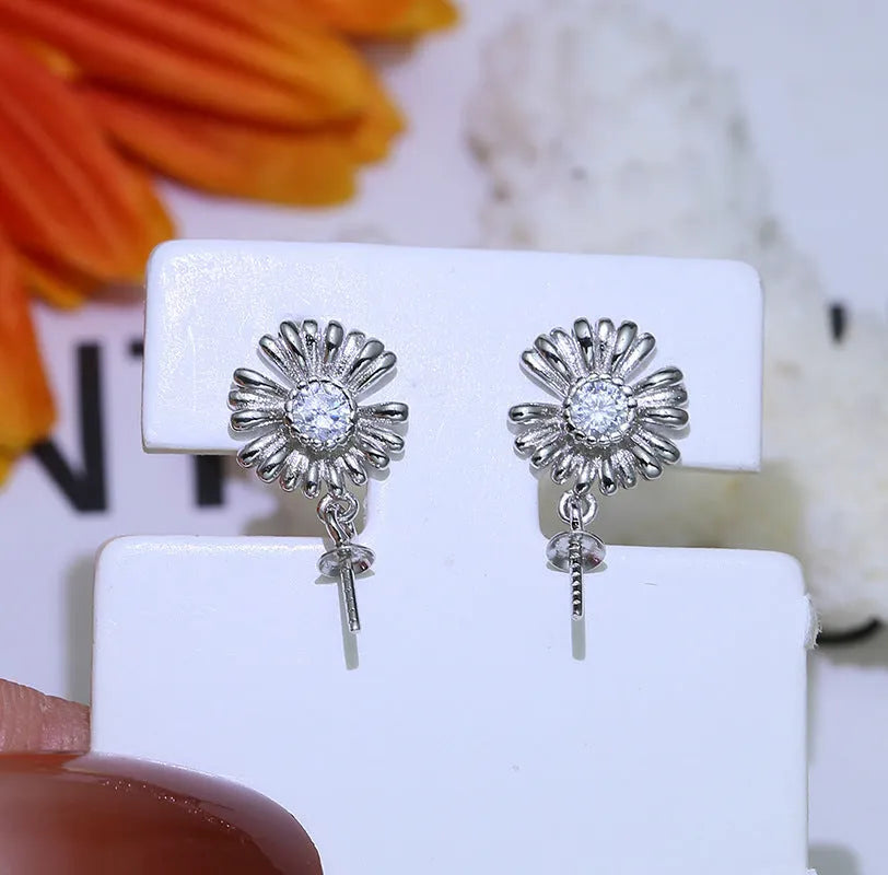 A pair of baroque-style flower drop earrings with intricate openwork, made from 925 sterling silver on a plain background.