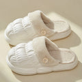 Removable fluffy slippers in beige with faux fur lining and Velcro fastening on a wooden floor