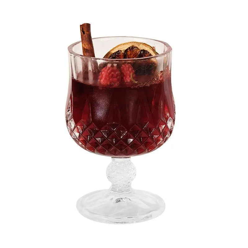 Glass wine goblet shaped container holding a French mulled wine scented aromatherapy candle.