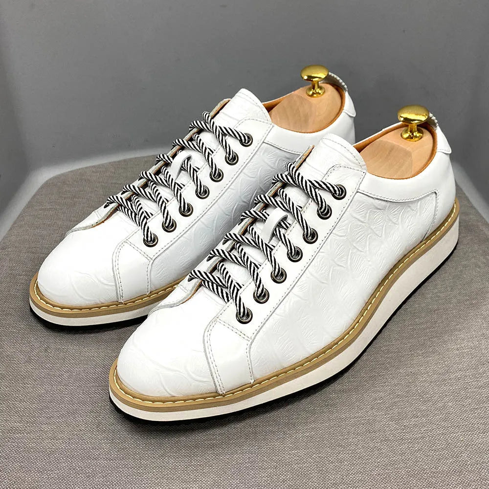 Men's low-top handmade shoes with embossed pattern on front, showing front-tie laces and grey colour.