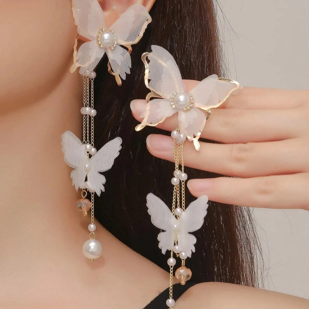 White butterfly-shaped tassel earrings with pearls and sparkling rhinestones on a copper alloy base.