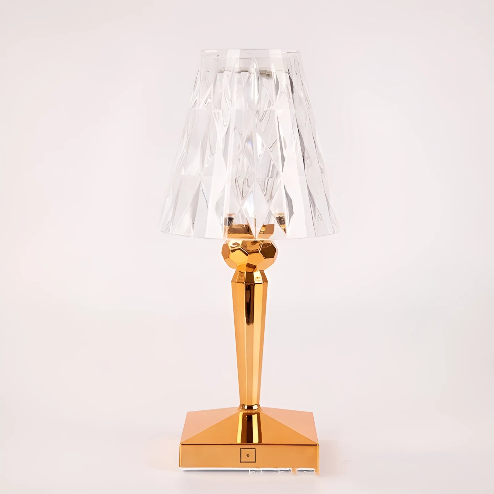 Rose gold plated portable touch night light with acrylic body on a surface.