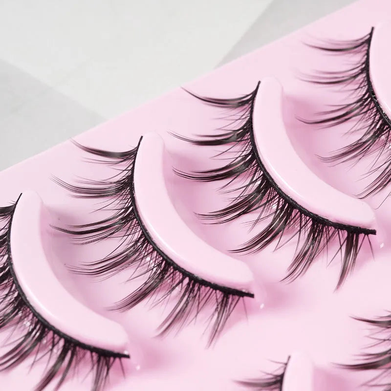Five pairs of natural wispy manga false eyelashes in a tray, anime cosplay makeup style