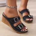 Creamy-white women's wedge slippers with a buckle strap on a black sole.