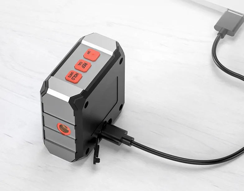 Longyun digital laser infrared tape measure with alloy casing and backlit display on a wooden workbench.