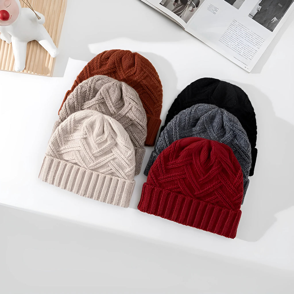 Woman wearing a knitted wool beanie with a dome crown and tribal totem pattern in Ankela Red.