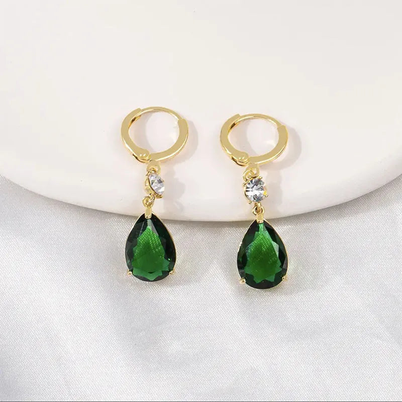 A pair of green geometric teardrop-shaped alloy fashion earrings on a plain background.