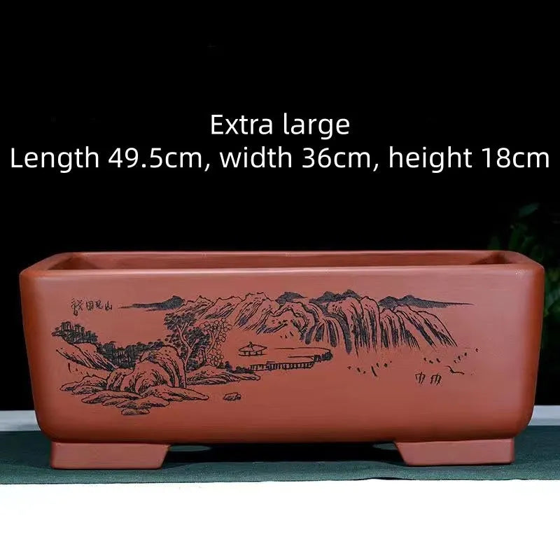 Handmade deep blue black rectangle purple clay bonsai pot on a wooden surface.