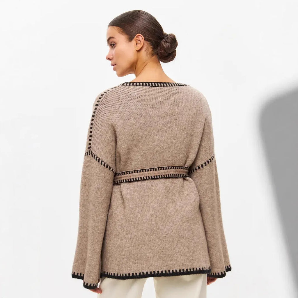 Lace-up front knitted cardigan in a camel colour, shown loose and open over a top.
