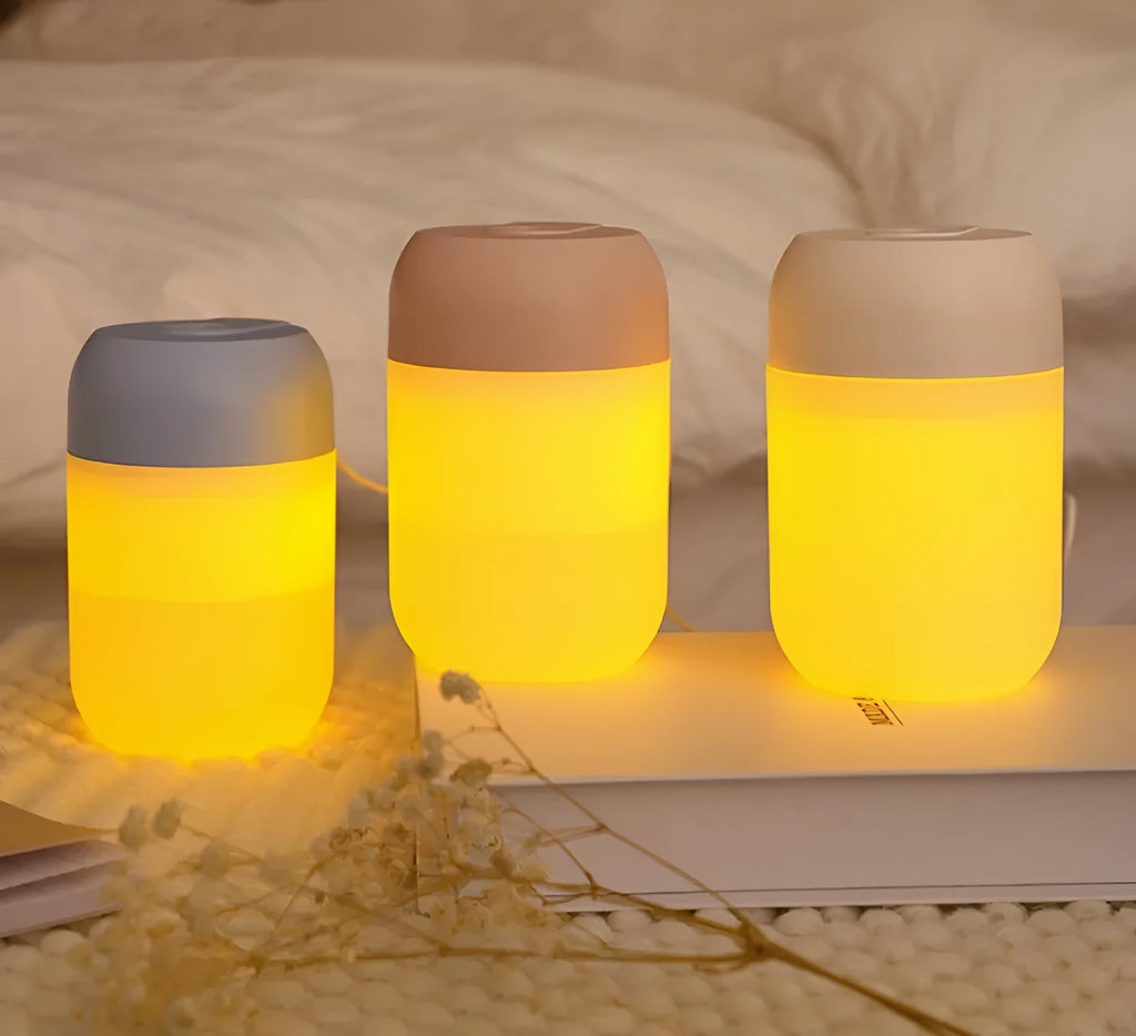 Small white cylindrical USB humidifier with aromatherapy diffuser on a wooden surface.