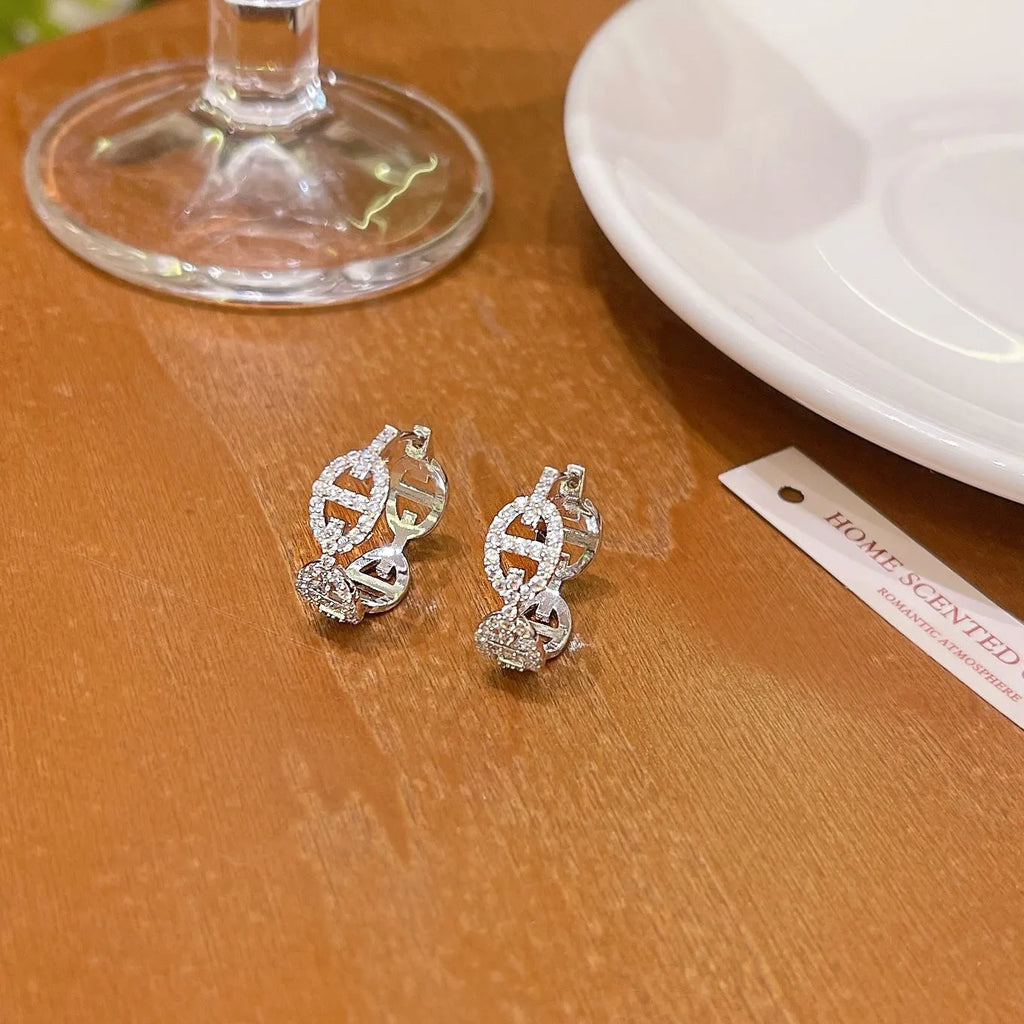 A pair of casual ladies earrings with a diamond-like detail, shown in an electroplated silver, gold, or rose gold finish.