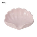 White shell-shaped plastic soap dish on a bathroom countertop.