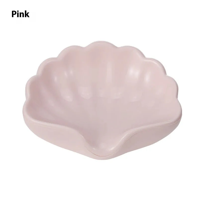 White shell-shaped plastic soap dish on a bathroom countertop.