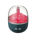 Green ultrasonic aromatherapy humidifier with heavy fog and colourful gradient light on a desk