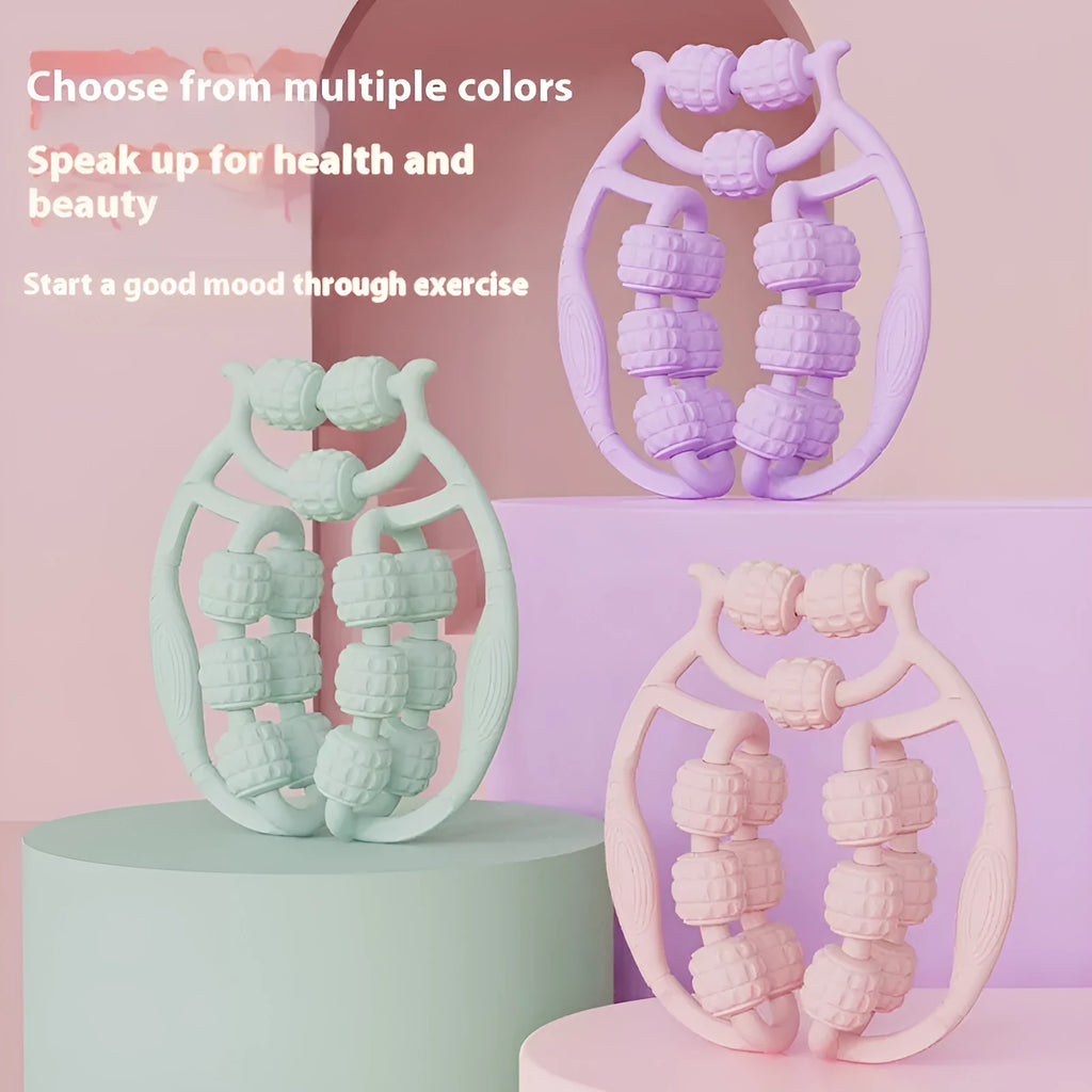 A small, handheld leg massage roller with double-row wheels in coral pink, shown on a table.