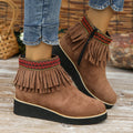 Women's suede ankle boots with a thick wedge platform sole, side zipper, and tassel detail in dark brown.