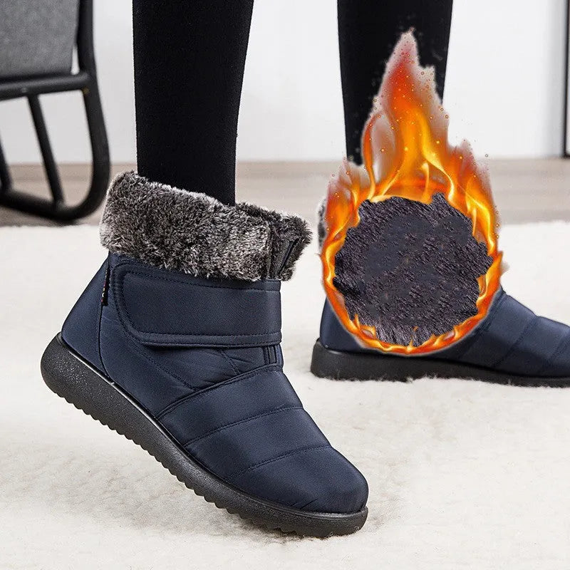 Women's winter snow boots with plush lining, suede upper, velcro strap, flat heel, and anti-skid rubber sole in black.