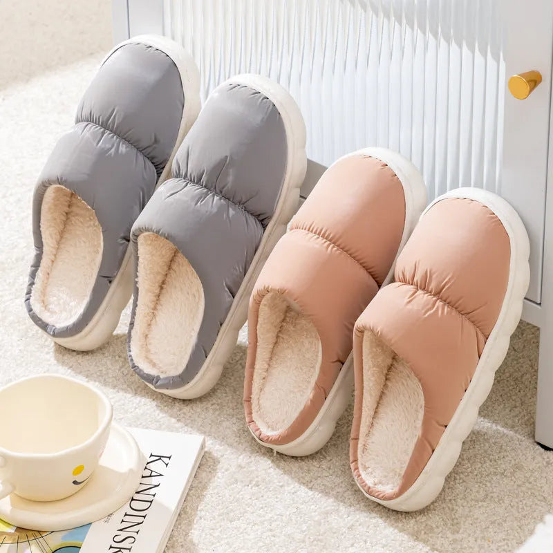 A pair of thick-soled house slippers with an artificial leather upper and plush lining, shown in a selection of colours.