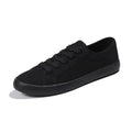 All black women's canvas lace-up work shoes with flat rubber sole on a white background.