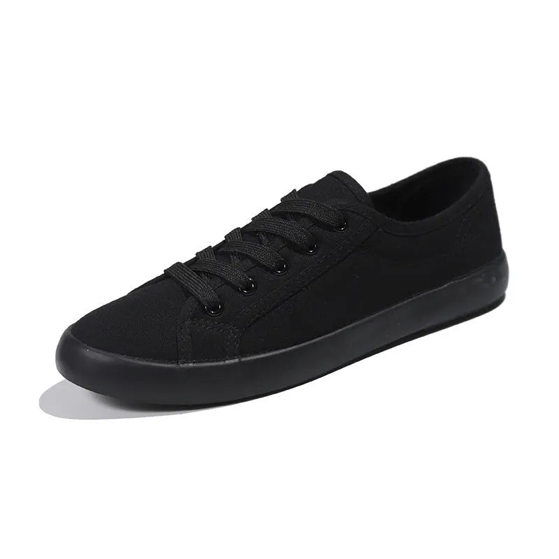 All black women's canvas lace-up work shoes with flat rubber sole on a white background.