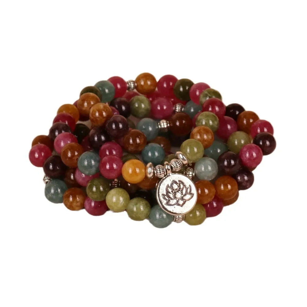 108 bead multi-layer bracelet in tourmaline colour with alloy details on a wrist.