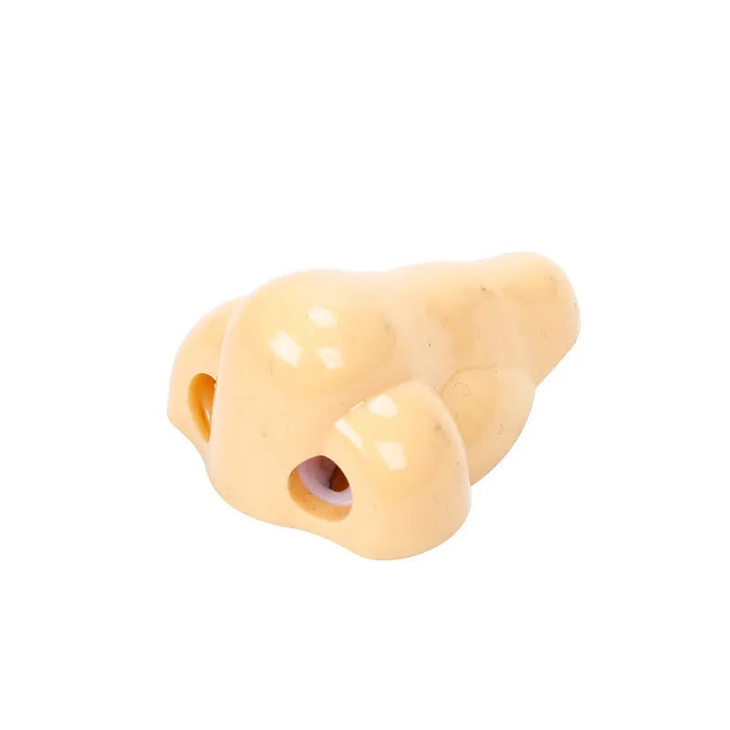 Flesh-coloured plastic student pencil sharpener with geometry design on a white background.