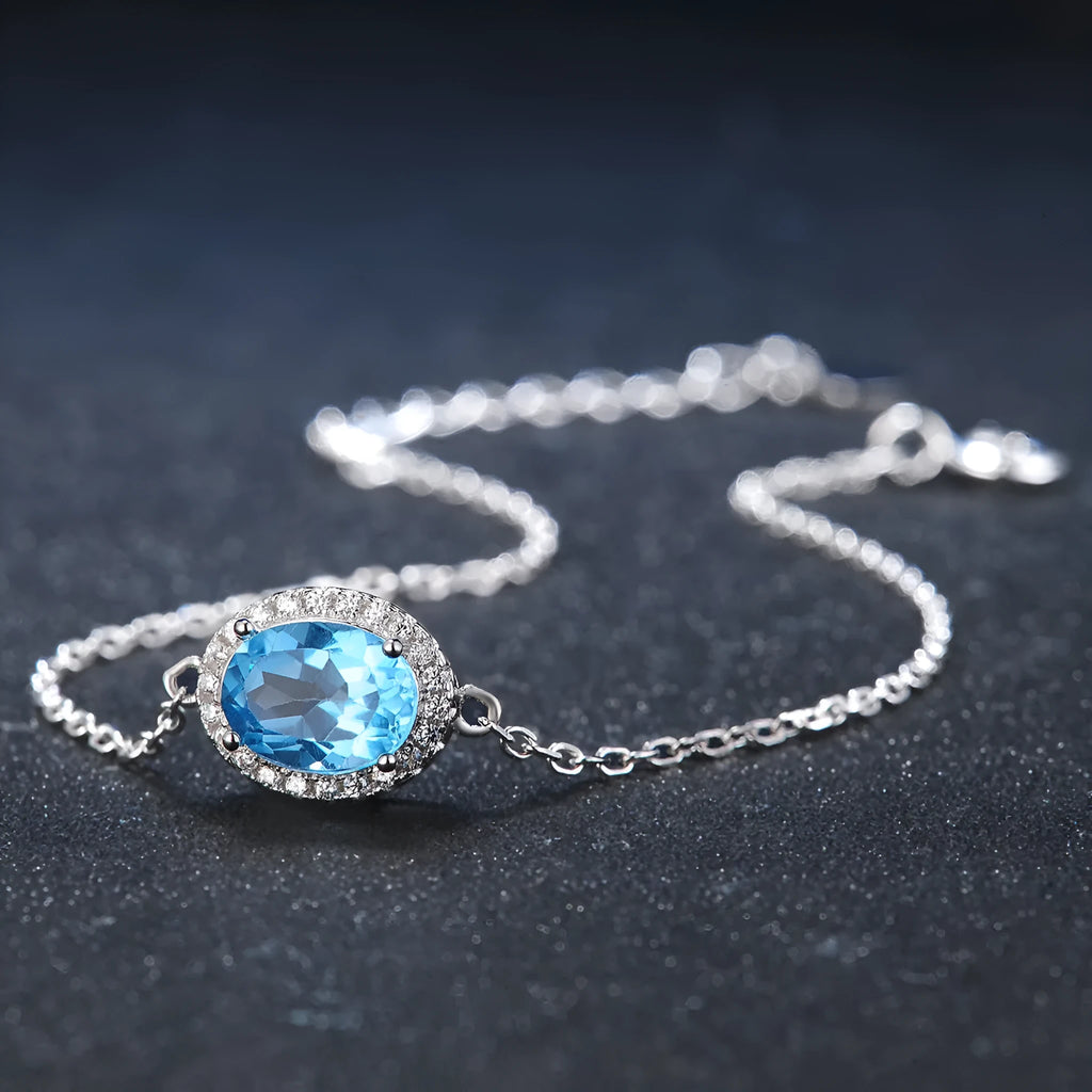 Geometric design women's sterling silver and blue topaz jewellery set showing earrings, ring, pendant, and necklace.