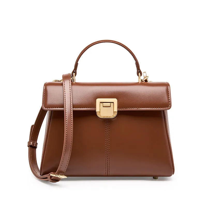 Women's black genuine leather shoulder bag with a clasp, shown with adjustable strap and open to reveal internal zippered pocket.