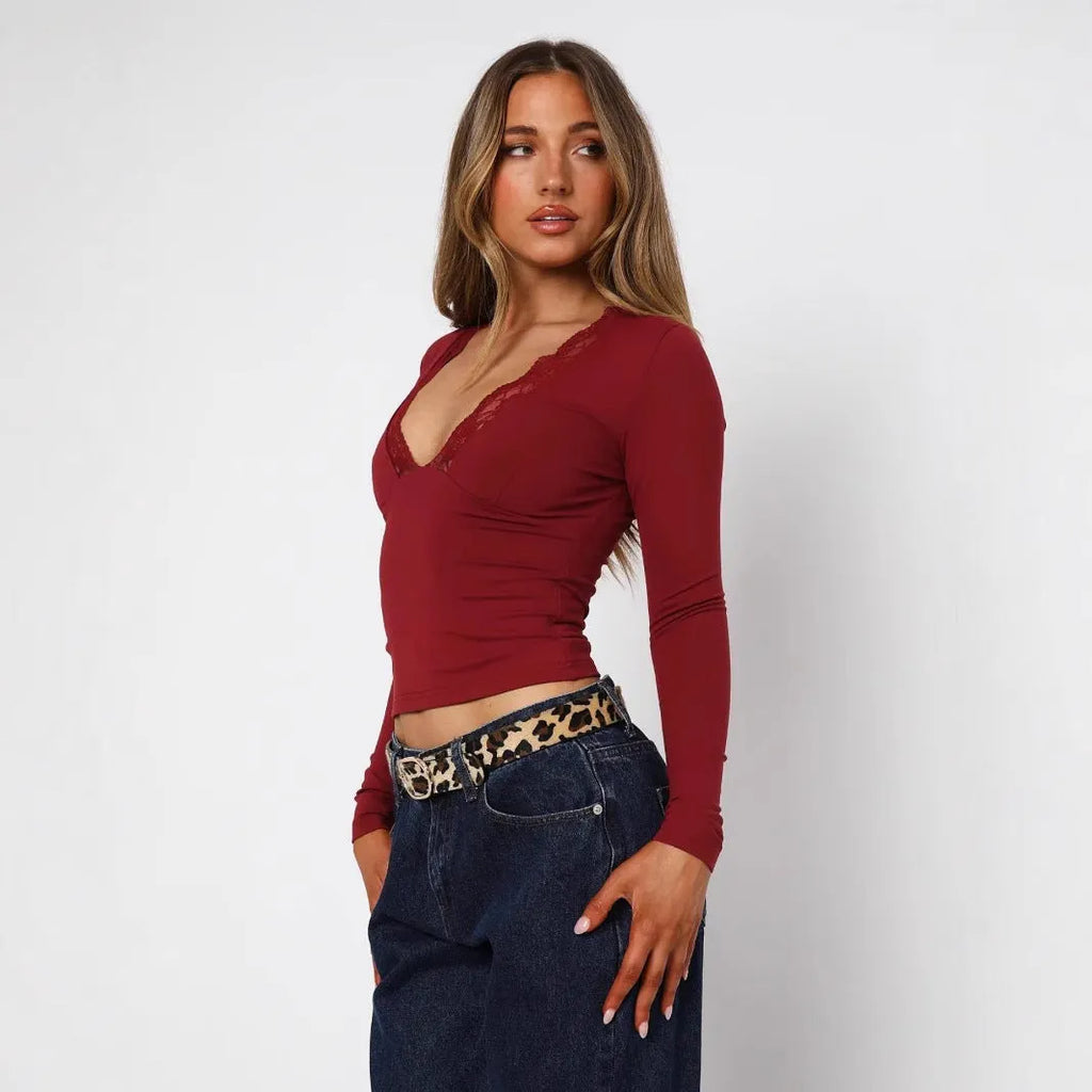 Women's black slim-fit long sleeve top with white lace flower decoration on the front.