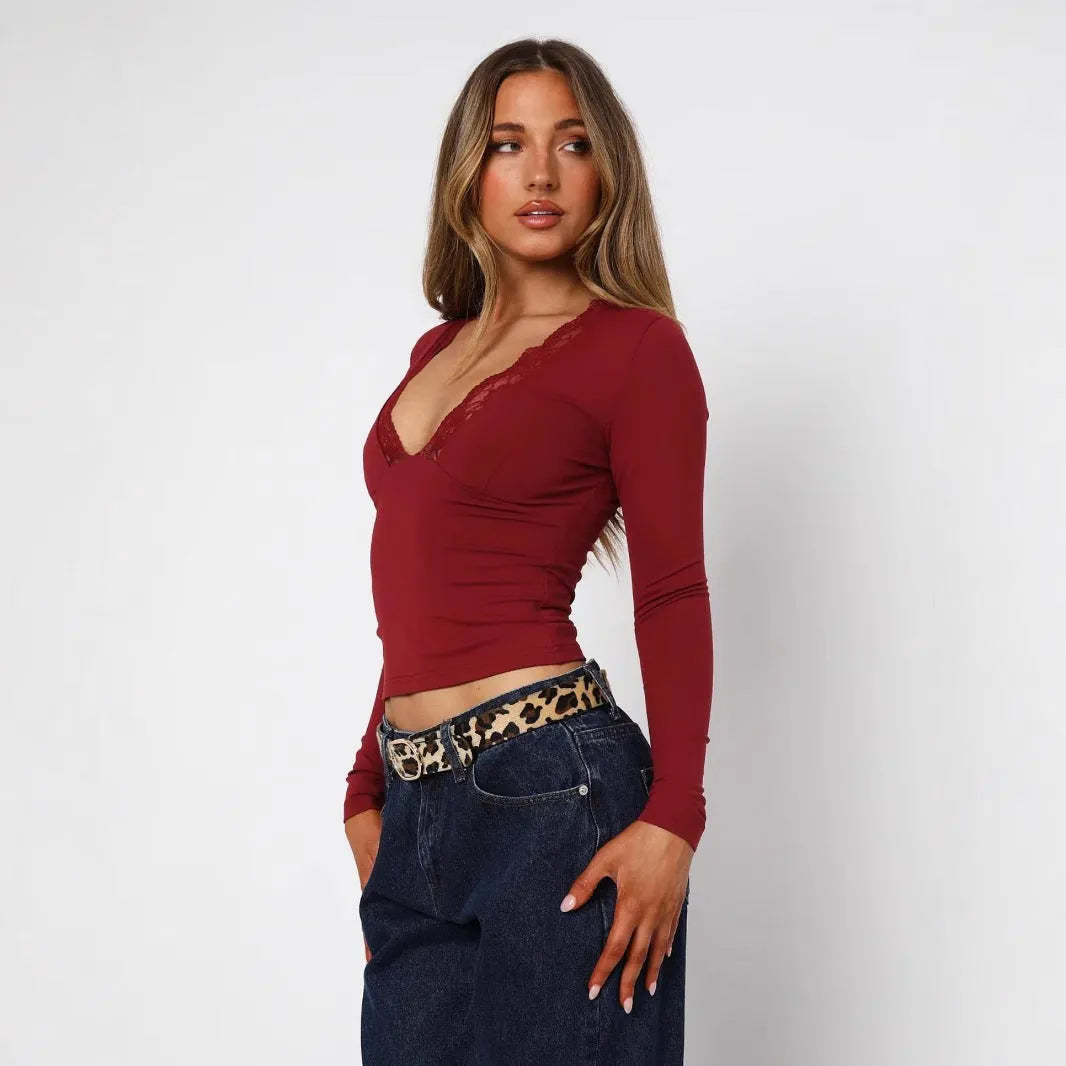 Women's black slim-fit long sleeve top with white lace flower decoration on the front.