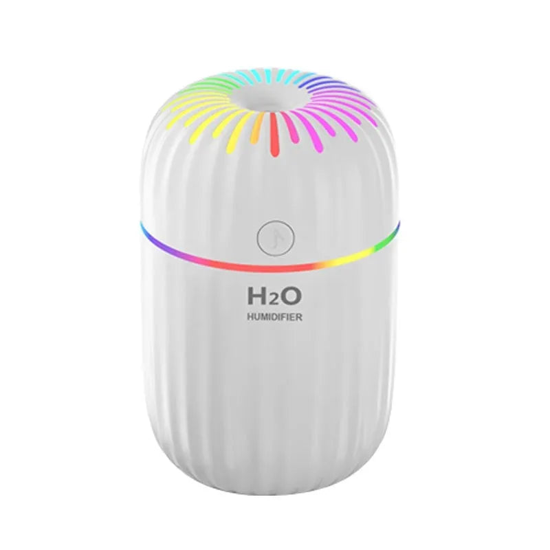 White USB portable mini humidifier with water tank on desk beside laptop