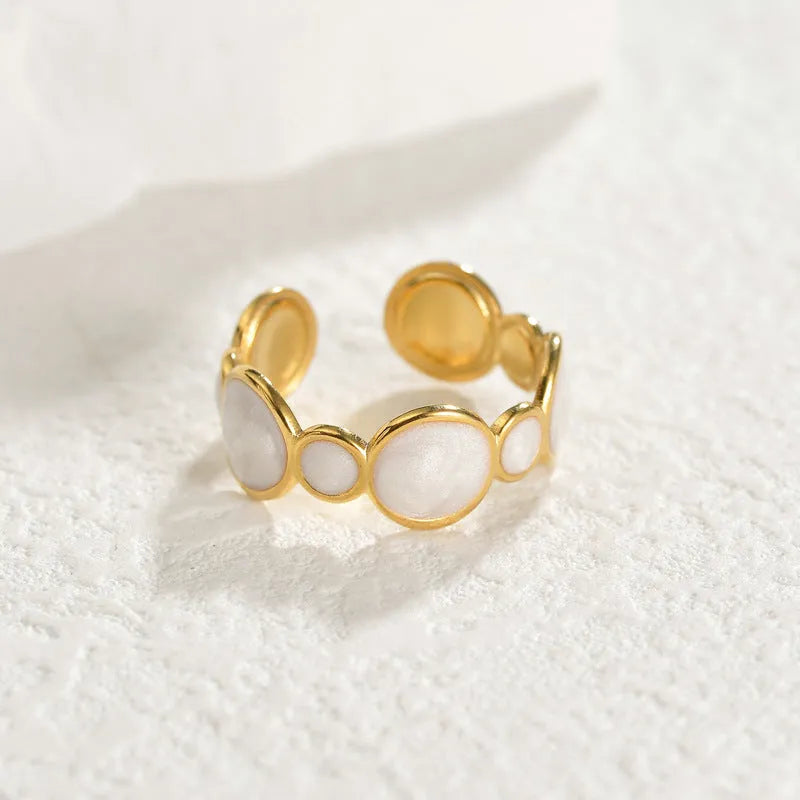 Geometric stainless steel ring with adjustable opening on a plain background.