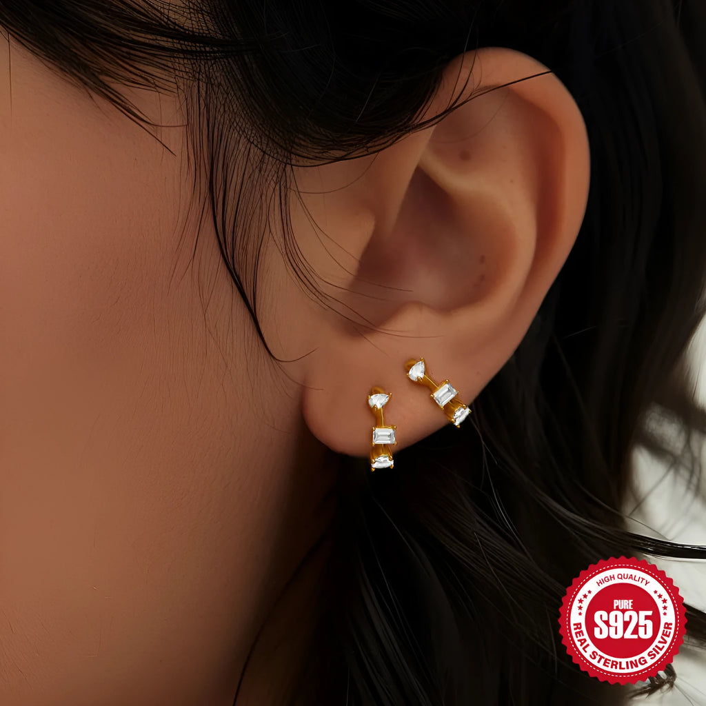 A pair of sterling silver geometric stud earrings with small round accents, shown in gold plating.