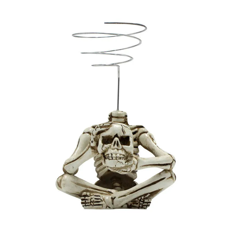 Gothic style skull design resin bracket holder for tillandsia air plants on a dark background.