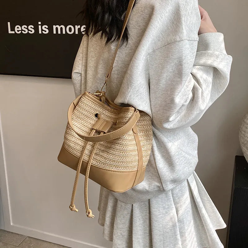 Brown woven straw women's crossbody bucket bag with horizontal square shape and adjustable strap